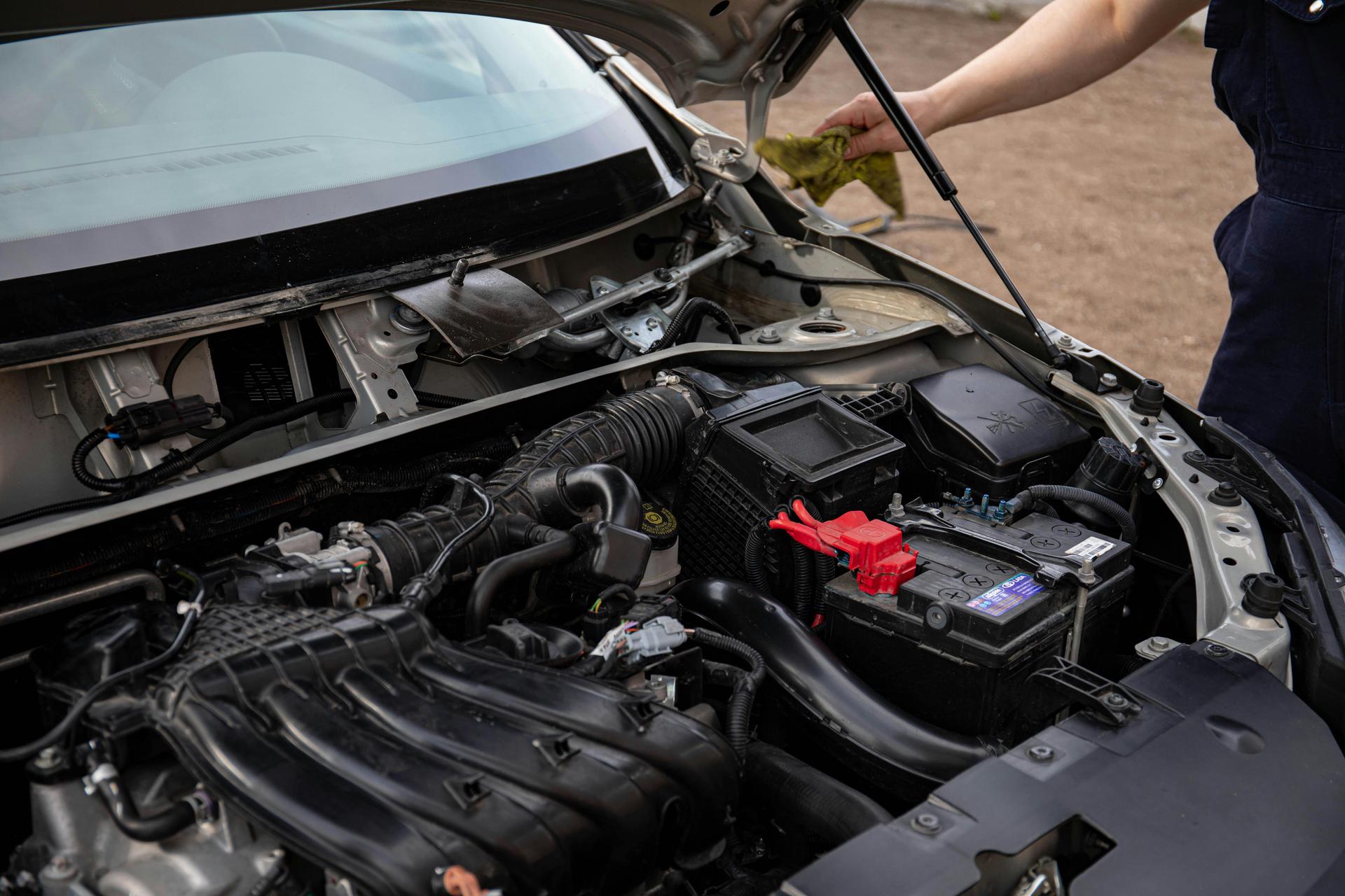 Mechanic servicing a car's battery at Shurlock Row garage